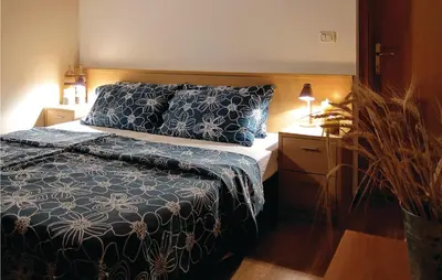 a bedroom with a bed with a blue and white comforter at 3 Bedroom Amazing Home In Tolmin in Tolmin