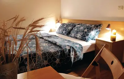 a hotel room with a bed with blue and white sheets at 3 Bedroom Amazing Home In Tolmin in Tolmin
