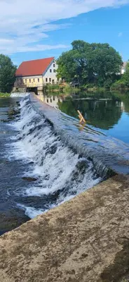 a body of water with a building in the background at Soba Kolovrat in Straža