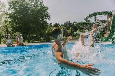 a group of people playing in a swimming pool at Soba Kolovrat in Straža