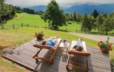 two people laying in lawn chairs on a wooden deck at Beautiful Apartment In Mozirje in Mozirje