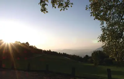 a sun setting on a hill with a field at Beautiful Apartment In Mozirje in Mozirje
