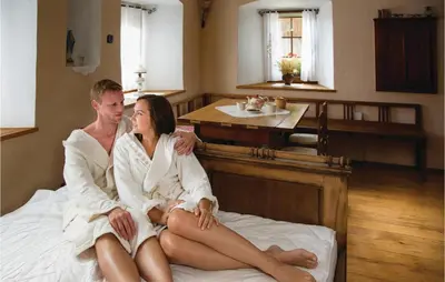 a man and woman in towels sitting on a bed at Beautiful Apartment In Mozirje in Mozirje