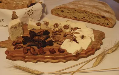 a cutting board with cheese and a loaf of bread at Beautiful Apartment In Mozirje in Mozirje