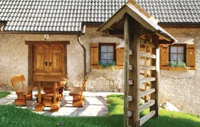 a wooden table and chairs in front of a building at Beautiful Apartment In Mozirje in Mozirje