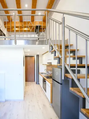 a kitchen with a staircase in a loft at The Lovely Loft in Ljubljana