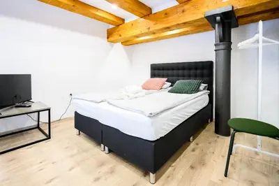 a bedroom with a bed and a desk and a tv at The Lovely Loft in Ljubljana