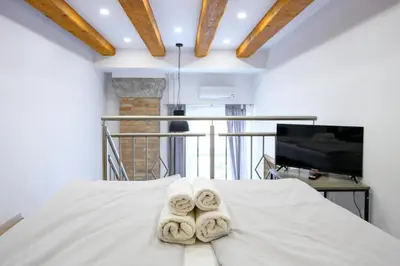 a bedroom with a bed with towels on it at The Lovely Loft in Ljubljana