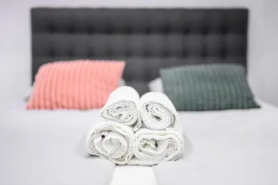 a pile of rolled towels on a bed with two pillows at The Lovely Loft in Ljubljana