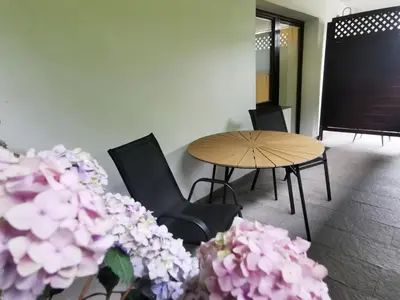 a room with a table and chairs and flowers at Apartments Bassanese in Bled