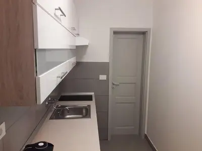 a small kitchen with a sink and a door at Apartments Bassanese in Bled