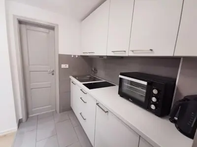 a kitchen with white cabinets and a black microwave at Apartments Bassanese in Bled