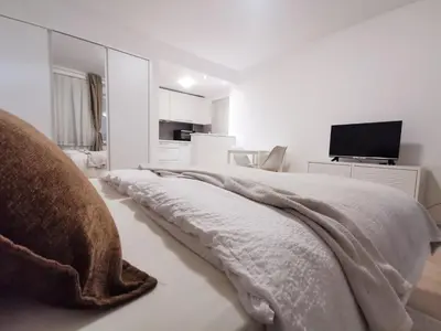 a white bedroom with a bed with a blanket at Apartments Bassanese in Bled