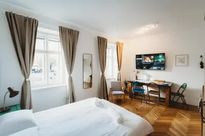 a bedroom with a bed and a desk and a table at The Muse' Hideaway in Ljubljana