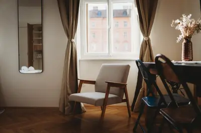 a dining room with a chair and a window at The Muse' Hideaway in Ljubljana