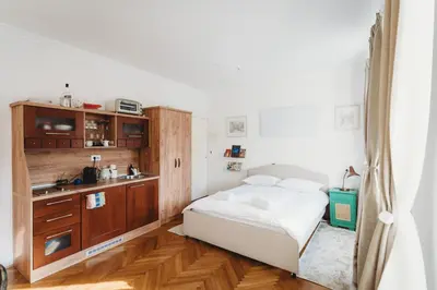 a small bedroom with a bed and a kitchen at The Muse' Hideaway in Ljubljana