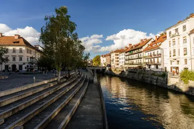 a river in a city with buildings next to a canal at The Muse' Hideaway in Ljubljana