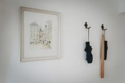 a picture hanging on a white wall with a wand at The Muse' Hideaway in Ljubljana