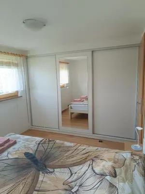 a bedroom with a large mirror on the wall at Hiška na gorci in Podčetrtek