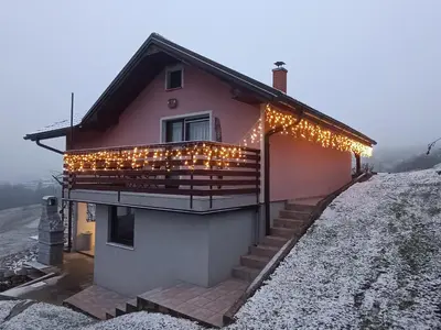 a house with christmas lights on the side of it at Hiška na gorci in Podčetrtek