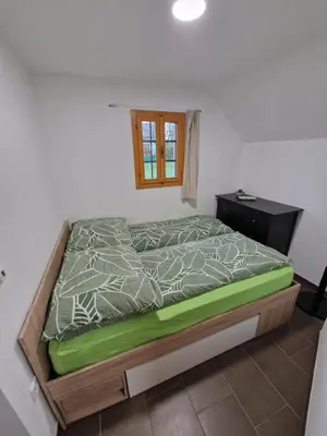 a bedroom with a bed with a green and white comforter at Sweet Country House in Markovci
