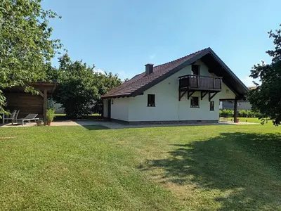 a white house with a balcony and a yard at Sweet Country House in Markovci