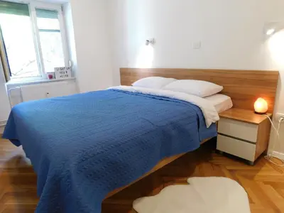a bedroom with a bed with a blue blanket at Modern Apartment Hrenova Street in Ljubljana