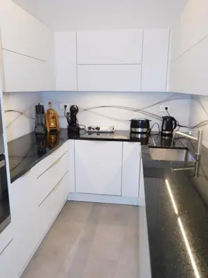 a white kitchen with white cabinets and appliances at Modern Apartment Hrenova Street in Ljubljana