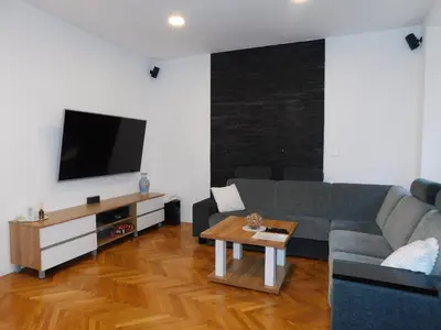 a living room with a couch and a tv at Modern Apartment Hrenova Street in Ljubljana