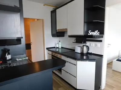 a kitchen with black counter tops and white cabinets at Elegant Apartment Poklukarjeva Street in Ljubljana