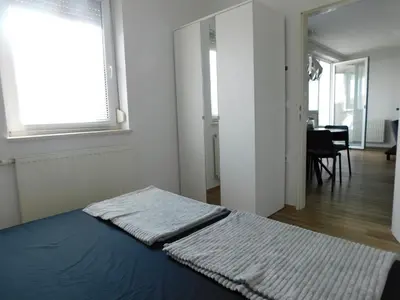 a bedroom with a bed with a blue blanket on it at Elegant Apartment Poklukarjeva Street in Ljubljana