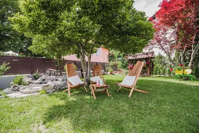 three chairs and a tree in a yard at Studio Mobile Home Gotar in Kobarid