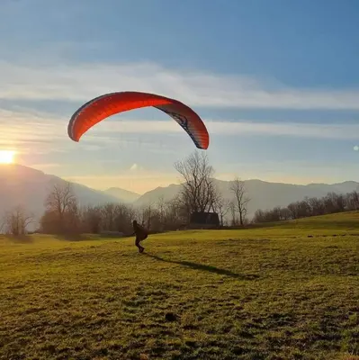 a person flying a parachute in a field at Studio Mobile Home Gotar in Kobarid