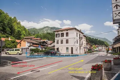 an empty street with a white building on the corner at Studio Mobile Home Gotar in Kobarid