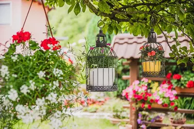 two bird cages with flowers in a garden at Studio Mobile Home Gotar in Kobarid