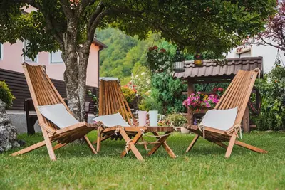 three chairs and a picnic table in the grass at Studio Mobile Home Gotar in Kobarid