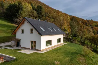 a white house with a black roof on a hill at Styria Estate, near Terme Olimia Spa Resort in Podplat