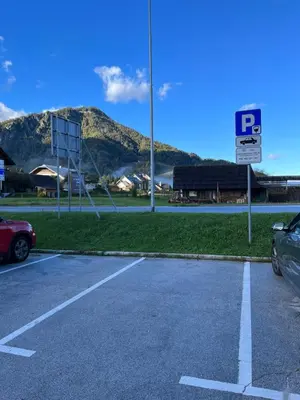 a parking lot with a parking sign in front of a mountain at Little King - Feel like at home in Kranjska Gora