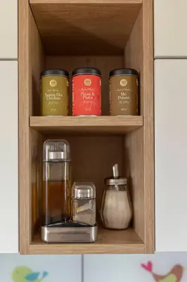 a cupboard with a shelf with jars and a glass at Apartments Nikolaj in Preddvor