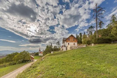 a house on top of a hill with a road at Apartments Nikolaj in Preddvor