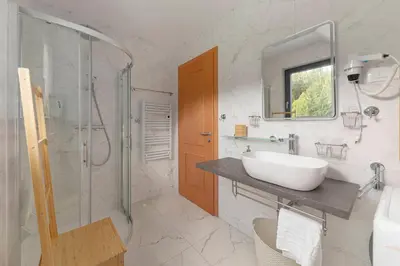 a white bathroom with a sink and a shower at Apartments Nikolaj in Preddvor