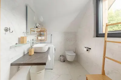 a white bathroom with a sink and a toilet at Apartments Nikolaj in Preddvor
