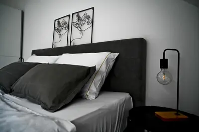 a bed with black and white pillows in a bedroom at Apartment Lilly in Slivnica pri Mariboru