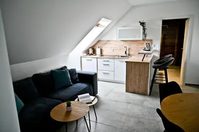 a living room with a couch and a table and a kitchen at Apartment Lilly in Slivnica pri Mariboru