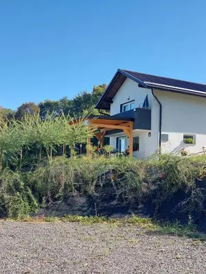 a house on the side of a hill with bushes at Apartma Ob jezeru in Gradišče v Slovenskih Goricah