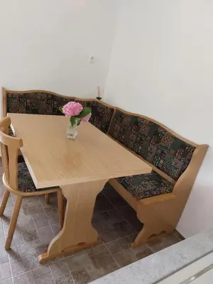 a wooden table with a vase of flowers on it at Apartma Ob jezeru in Gradišče v Slovenskih Goricah