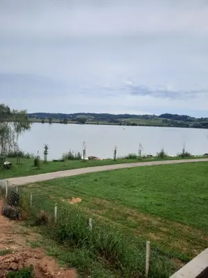 a road next to a large body of water at Apartma Ob jezeru in Gradišče v Slovenskih Goricah