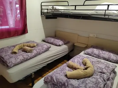 two beds in a room with bunk beds at F96 TERME OLIMIA, Aqualuna KAMP NATURA PODČETRTEK card included all year in Podčetrtek