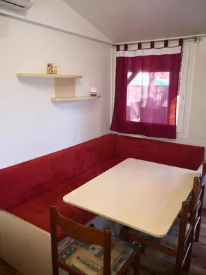 a red booth with a table and two chairs at F96 TERME OLIMIA, Aqualuna KAMP NATURA PODČETRTEK card included all year in Podčetrtek
