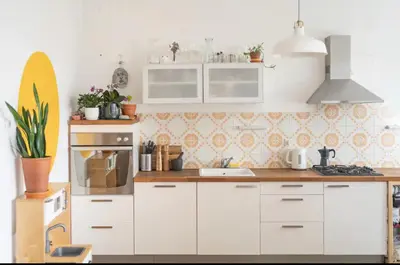 a kitchen with white cabinets and a surfboard on the wall at Family apartment in the city centre - FREE parking garage in Ljubljana